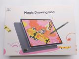 someone is drawing on a tablet with a pen in front of a box