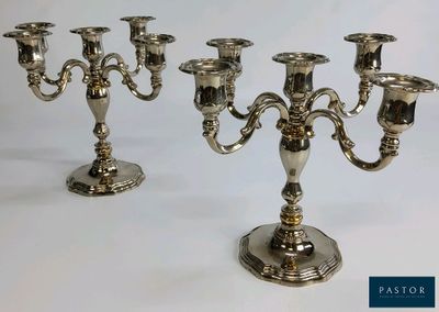 trois chandeliers en argent posés sur une table