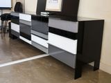 une commode noire et blanche sur laquelle est posée une télévision