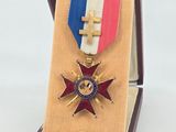 an image of a medal in a box with a cross on it