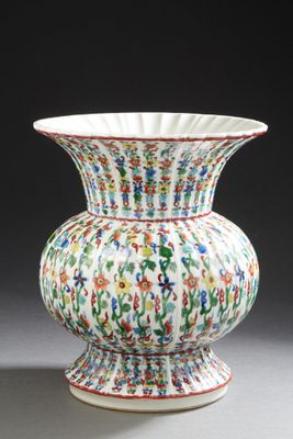a white vase with colorful flowers on it on a table