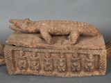 une image représentant une boîte en bois sur laquelle est posé un lézard