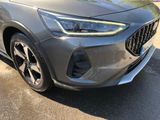the front end of a grey car parked in a parking lot