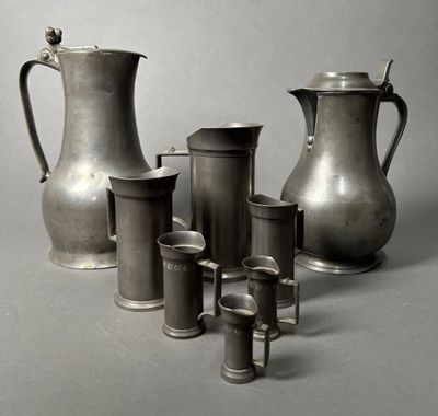 a lot of silver vases and cups sitting on a table