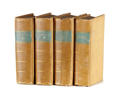 trois vieux livres posés l'un sur l'autre sur une surface blanche
