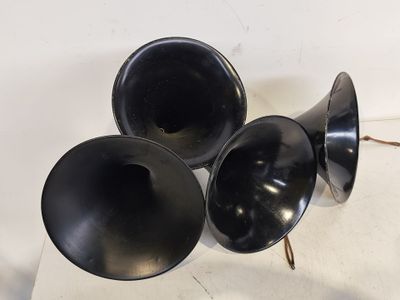 trois enceintes noires posées sur une surface blanche