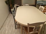 a table and chairs in a room with a mirror on the wall