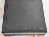 a small table with a black top and wooden legs