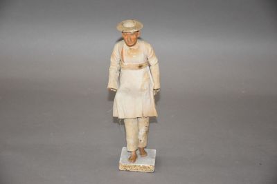 Statuette figurant un homme en terre cuite vêtu d'un habit d…