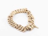 a close up of a gold chain bracelet on a white surface