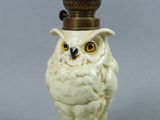 une figurine représentant un hibou blanc posée sur une table