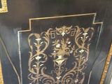 a black and gold painted cabinet sitting on top of a tiled floor