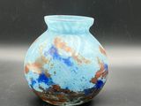 a blue vase sitting on a table with a black background