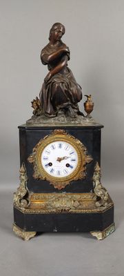 a statue of a woman sitting on top of a clock