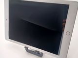 a person holding a tablet that is on a stand