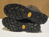 the soles of a pair of black hiking shoes on a white surface