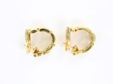 a pair of gold earrings with a white stone in the middle