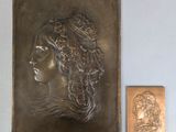 an image of a bronze plaque with a woman ' s face on it