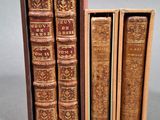 trois vieux livres dans une boîte en bois posée sur une table