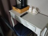 une table blanche sur laquelle se trouvent une cafetière et un téléphone