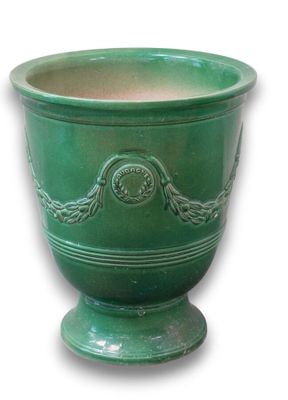 a green planter that is sitting on a white surface