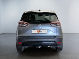 the rear end of a silver car in a white room