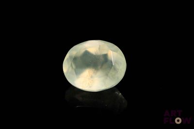 une image représentant une pierre de quartz blanche posée sur une surface noire