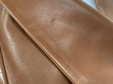 a close up of a brown leather bag on a table