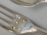 a cup of coffee with a spoon and fork on the table