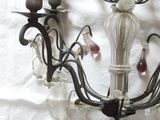 a chandelier with two candles on it on a white sheet