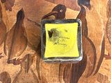 une photo d'un tableau posé sur une table, sur lequel est collé un autocollant jaune