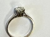 une image d'une bague en diamant sur une surface blanche
