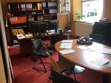 une photo d'un bureau avec un bureau et des chaises