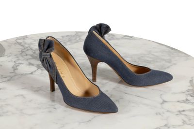 Les chaussures de la femme sont posées sur une table en marbre dont le plateau est également en marbre.