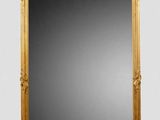 an image of a gold framed mirror sitting on top of a white wall