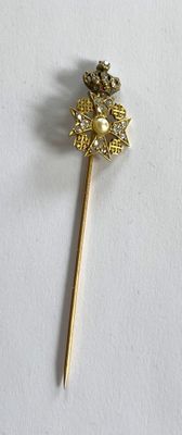 un bâton doré orné d'une fleur, posé sur un fond blanc