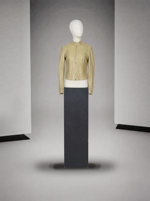mannequin devant un mur blanc, vêtu d'un pull jaune