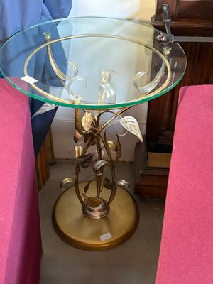 une table avec un plateau en verre sur lequel est posée une feuille d'or