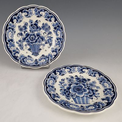 two blue and white plates with flowers on them on a table