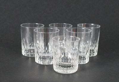 quatre verres transparents sont alignés sur une surface noire