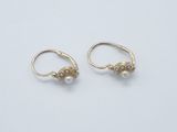 a pair of gold earrings with pearls on them