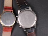 two watches sitting next to each other on a table