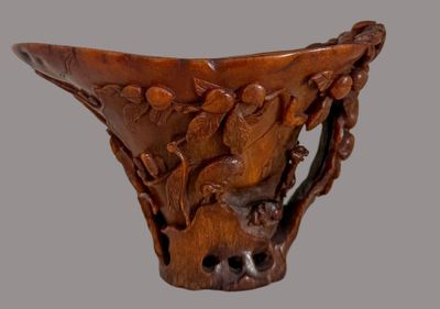 a close up of a wooden vase with carvings on it