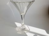 a glass vase sitting on a table with a shadow on it
