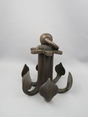 une statue en bronze représentant un oiseau posé sur une ancre