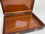a small wooden box that is open on a white surface