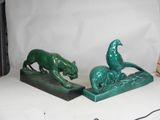 pair of green bookends of a cat and a dog on a rock