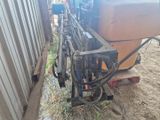 un tracteur attelé à une remorque, garé à côté d'un bâtiment