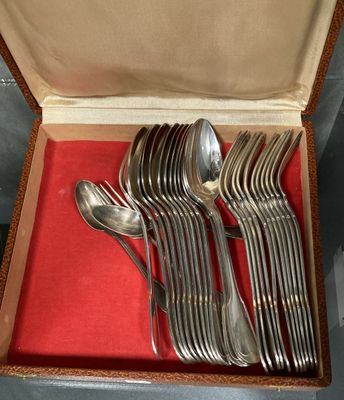 une boîte contenant de l'argenterie, posée sur une nappe rouge