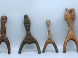 trois figurines en bois assises les unes à côté des autres sur une surface blanche